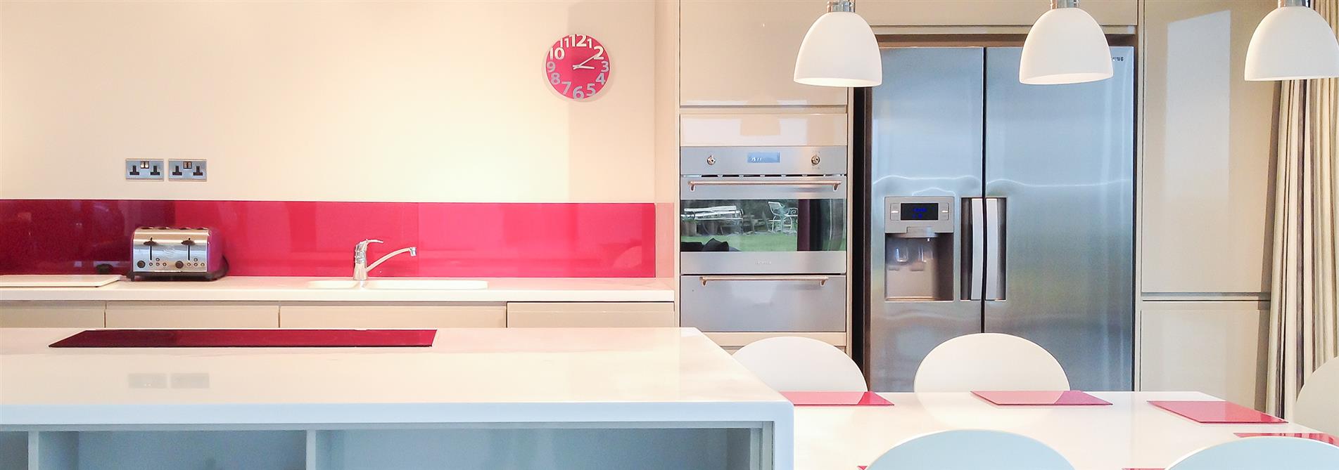 Kitchen with pink glass splashback